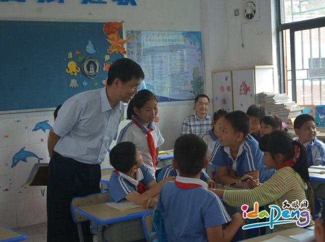 景山小学教师在课堂上辅导学生交流并运用慧学评六小家记录成长